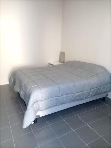 a bed sitting in a room with a white wall at Camino 124 NQN in Neuquén