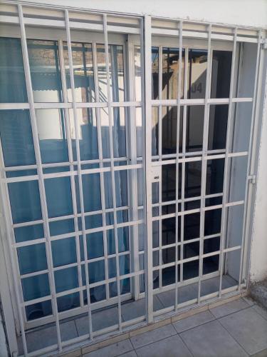 a glass door with metal bars on a building at Camino 124 NQN in Neuquén