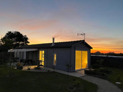 a small house with a sunset in the background at TI KAZ - Terrasse extérieure - 5mn Plage in Pleubian
