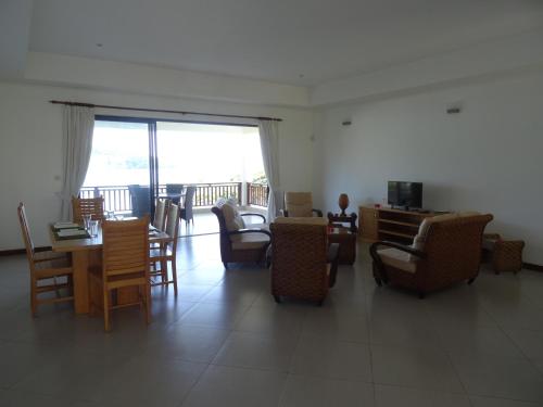 a living room with chairs and a table and a room with a balcony at Sailfish Beach Villas in Anse a La Mouche