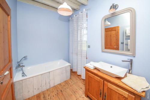 une salle de bain avec une baignoire, un lavabo et un miroir dans l'établissement Le Mazage des Trégans, à Gaillac