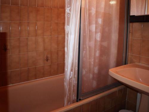 une salle de bain avec un rideau de douche et un lavabo dans l'établissement Grand studio cabine pour 6, proche des pistes, avec balcon et box à skis - Les Orres - FR-1-322-585, aux Orres
