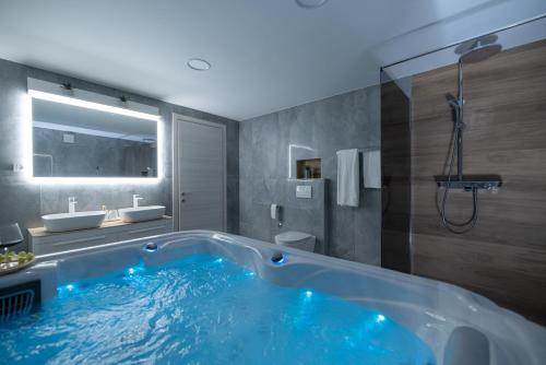 une grande baignoire dans une salle de bain avec un lavabo dans l'établissement Apartman NAI WITH PRIVATE JACUZZI AND PARKING, à Rijeka