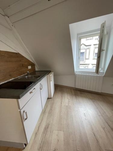 an attic kitchen with a sink and a window at Studio Mezzanine in Molsheim