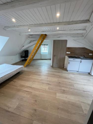 an empty room with a yellow ladder in the ceiling at Studio Mezzanine in Molsheim