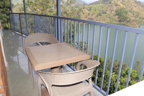 a wooden table and chairs on a balcony with a view at Home Saint Jean Ltd in Gitesi