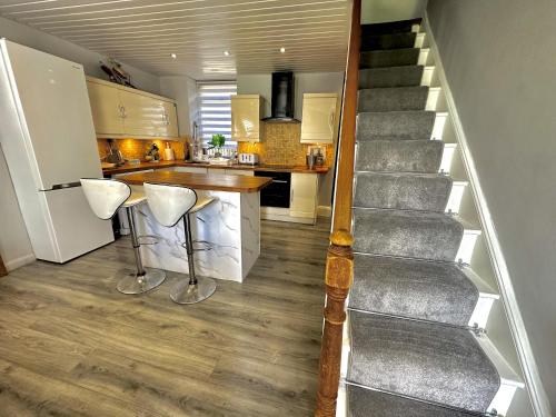 a kitchen with a staircase and a kitchen with a counter at Sleeps 8 Snowdonia North Wales Nr Zip World in Tanygrisiau