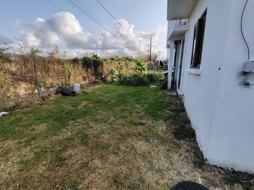 an empty yard next to a white house at Green Village in Grand Gaube