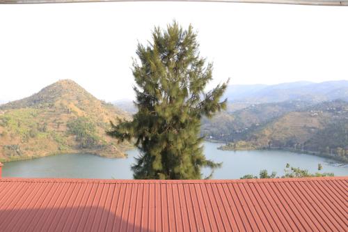 a tree in front of a river with a mountain at Home Saint Jean Ltd in Gitesi