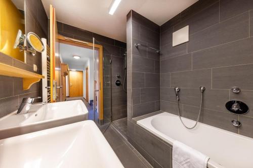 une salle de bain avec une baignoire et un lavabo dans l'établissement Schöneben Chalet Scorleduyn, à Wald im Pinzgau