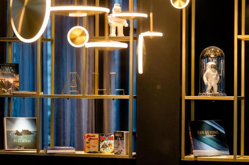 a shelf with books and a clock on it at Motel One Nürnberg-Plärrer in Nürnberg