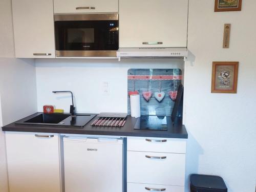 une cuisine avec un évier et un micro-ondes dans l'établissement Studio cosy avec balcon, 3 pers, à 750m des remontées mécaniques, parking et casier à skis inclus - FR-1-676-165, à Châtel