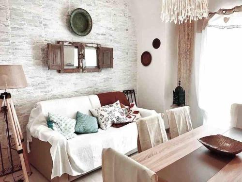 a living room with a white couch with pillows on it at Casa Failla - Das Nest am Meer in Siracusa