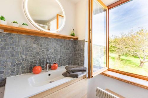 une salle de bain avec un lavabo et un miroir dans l'établissement Gîte de la Tour pour 10 personnes à Ganac, à Ganac