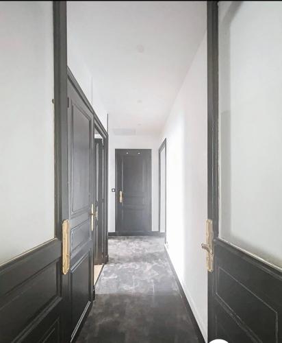 an empty hallway with black doors and white walls at Taylor 8 in Pau