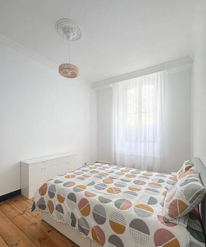 a bedroom with a bed with a comforter and a window at Taylor 8 in Pau