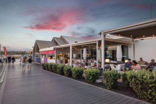 a group of people walking on a boardwalk at Barceló Fuerteventura Royal Level - Adults Only in Caleta De Fuste