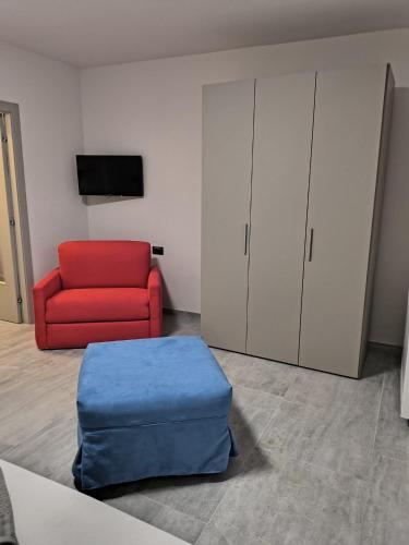 a living room with a red chair and a red ottoman at B&B Cà dei Nonni di Barbero Chiara in Calliano