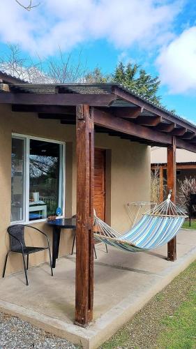a hammock on a patio with a house at Suite 1 Las Macluras in Tandil