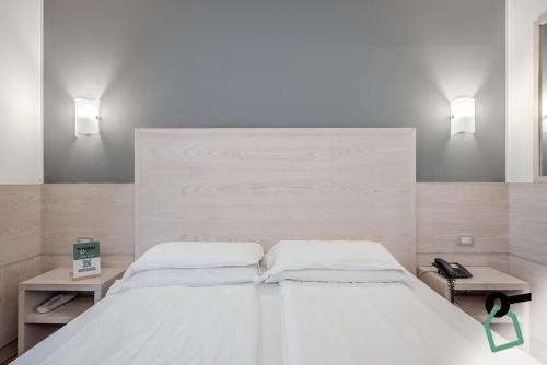 a bedroom with a large white bed with two lamps at HOTIDAY Room Collection - Torbole in Nago-Torbole