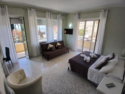 a bedroom with a bed and a couch and windows at affittacamere da Fenix in Tivoli