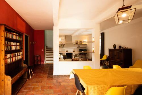 une salle à manger avec une table jaune et une cuisine dans l'établissement Gîte La Maison des Vendangeurs, à Villesèque-des-Corbières