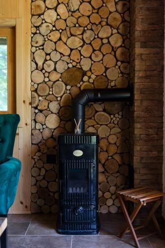 a wood stove in a room with logs on the wall at Riverside Cabin Pisak in Kulen Vakuf