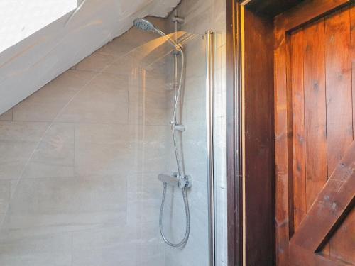 a shower in a bathroom next to a staircase at Clyne Farm Centre in The Mumbles