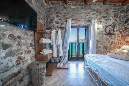 a bedroom with a bed and a stone wall at Petra Elounda Suites - Adults Only in Elounda