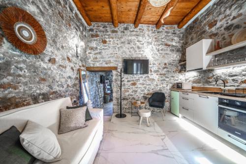 a living room with a couch and a stone wall at Petra Elounda Suites - Adults Only in Elounda