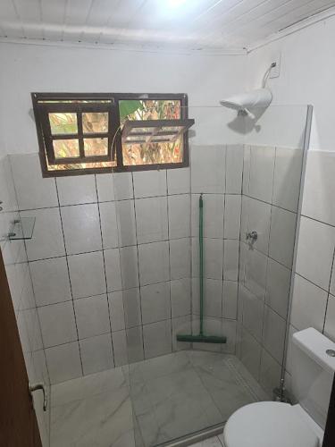 a bathroom with a shower with a toilet and a window at MangoBrazil in Imbassai