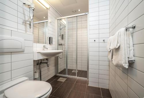 a bathroom with a toilet and a sink and a shower at Thon Partner Hotel Kristiansand in Kristiansand