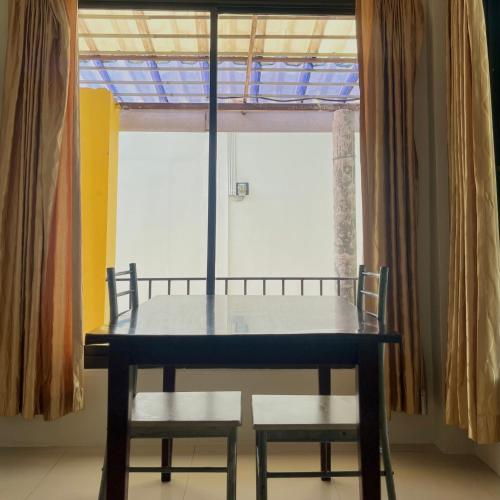 a table and two chairs in front of a window at บ้านพักสิริ มุกดาหาร (Baan Siri Mukdahan) in Ban Muang Ba