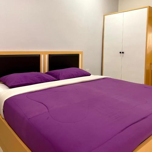 a bedroom with a purple bed with a cabinet at บ้านพักสิริ มุกดาหาร (Baan Siri Mukdahan) in Ban Muang Ba