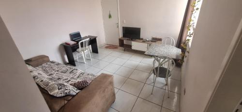 a living room with a couch and a desk at Apê simples, completo e bem localizado! in Hortolândia