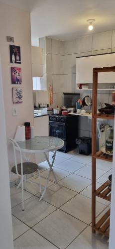 a kitchen with a table and a table and a stove at Apê simples, completo e bem localizado! in Hortolândia