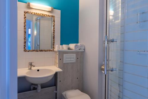 a bathroom with a sink and a mirror at The Originals Access, Hôtel Innostar in Labège