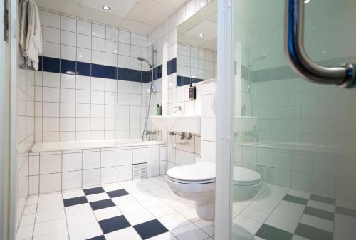 a bathroom with a toilet and a tub and a sink at Thon Partner Hotel Kristiansand in Kristiansand