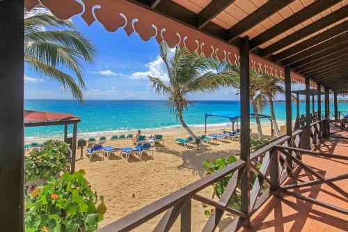 a view of a beach with a palm tree and the ocean at Mary's Boon Beach Resort & Spa in Simpson Bay