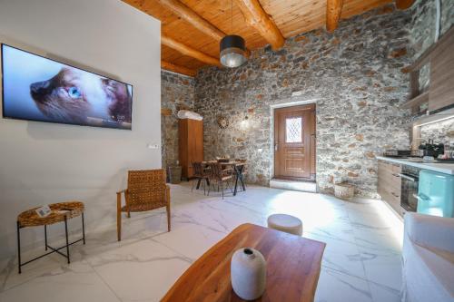 a living room with a tv on the wall at Petra Elounda Suites - Adults Only in Elounda