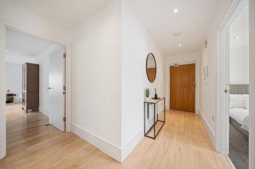 a white room with a bed and a mirror at 2 Bedroom Apartment in Kings Cross, London, N1 in London