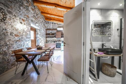 a kitchen and dining room with a table and a sink at Petra Elounda Suites - Adults Only in Elounda