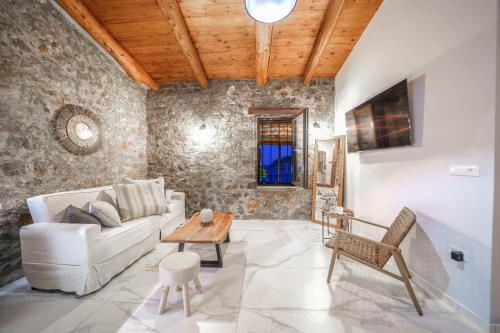 a living room with a white couch and a table at Petra Elounda Suites - Adults Only in Elounda