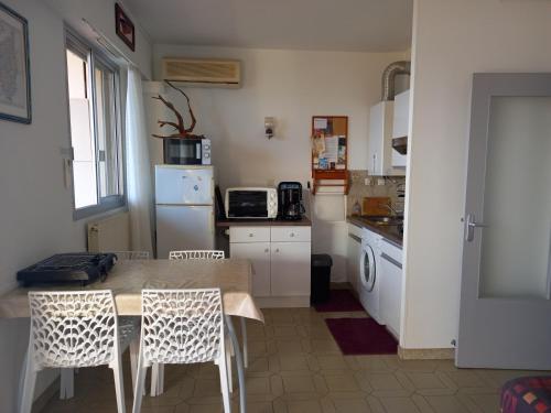 une cuisine avec une table, des chaises et un réfrigérateur dans l'établissement t1 bis vue imprenable, à Ajaccio