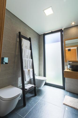 a bathroom with a white toilet and a sink at Refúgio de luxo com spa, piscina interior e exterior - Pedra Aguda Spa in Fornos de Maceira Dão