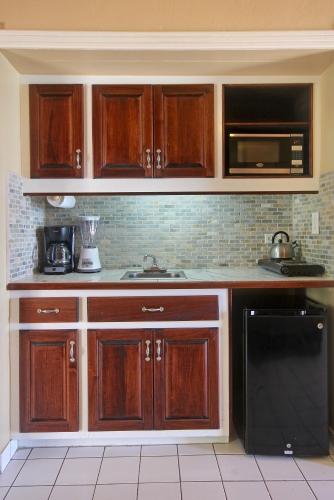 a kitchen with wooden cabinets and a black dishwasher at Mary's Boon Beach Resort & Spa in Simpson Bay