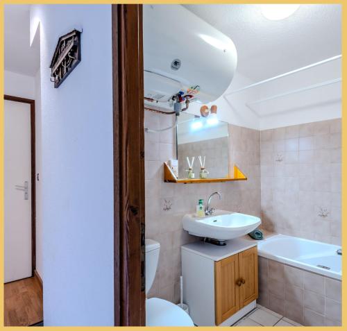 ein Badezimmer mit Waschbecken, Toilette und Badewanne in der Unterkunft La ferme I T2 I Les Gets in Les Gets