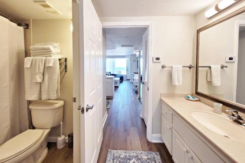 a bathroom with a sink and a toilet and a mirror at Daytona Beach Resort Unit #302 in Daytona Beach