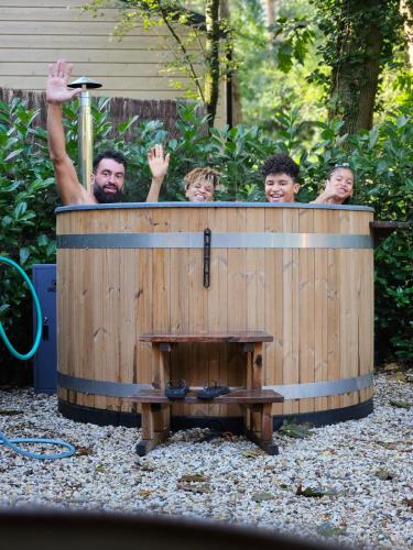 a group of people standing in a wooden barrel at Forest Finest, luxe chalet met HOT TUB mooie overkapping en prachtige tuin met veel privacy in Hoenderloo