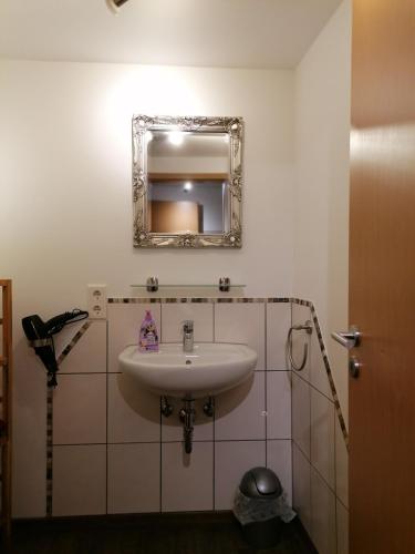 a bathroom with a sink and a mirror on the wall at Ferienwohnung Annalena in Gößweinstein